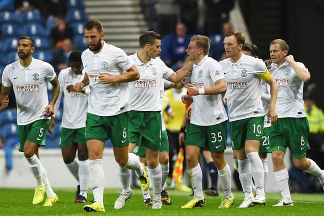 Jason Cummings (35) is mobbed by his team-mates as they celebrate his opener at Ibrox. Picture: SNS