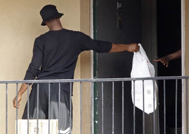A bag of supplies is passed into the Dallas flat of a Liberian who became the first Ebola case diagnosed on US soil. Picture: Reuters