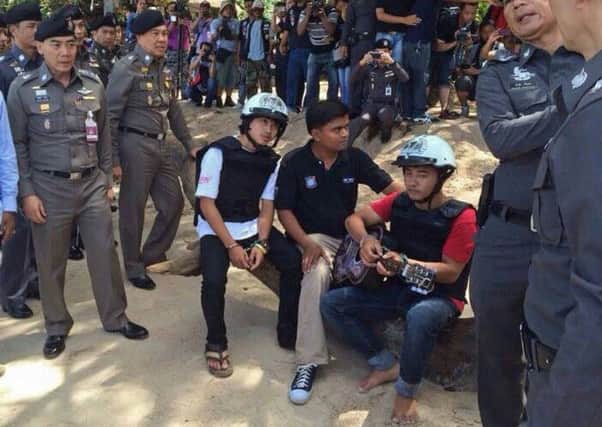Two men (wearing helmets) accused of killing British tourists re-enact crime scene. Picture: Getty