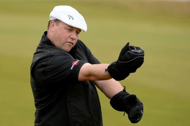 Chris Doak keeps his hands warm on the 18th fairway at Kingsbarns on his way to a second round 67. Picture: Getty Images