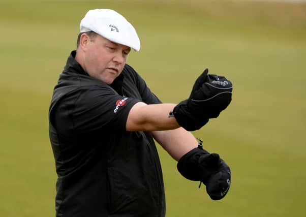Chris Doak keeps his hands warm on the 18th fairway at Kingsbarns on his way to a second round 67. Picture: Getty Images