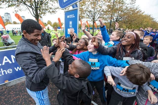 Haile Gebrselassie jokes with children at the Schools Challenge in Glasgow yesterday. Picture: Peter Devlin