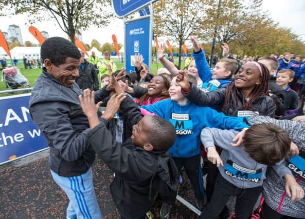Haile Gebrselassie jokes with children at the Schools Challenge in Glasgow yesterday. Picture: Peter Devlin