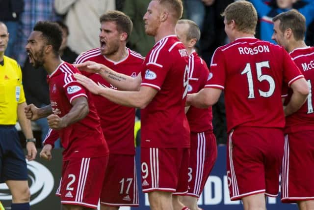 Aberdeens man of the match Shay Logan leads his teammates in celebration as they secured a 32 win away at Dundee on Saturday. Picture: Alan Harvey/SNS