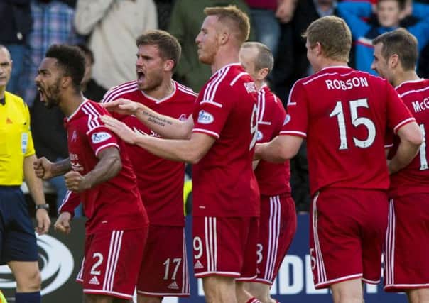 Aberdeens man of the match Shay Logan leads his teammates in celebration as they secured a 32 win away at Dundee on Saturday. Picture: Alan Harvey/SNS