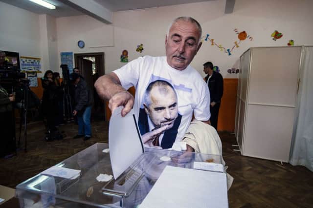 A man wearing a t-shirt with an image of Bulgarian strongman Boyko Borisov and GERB party leader casts his ballot. Picture: Getty