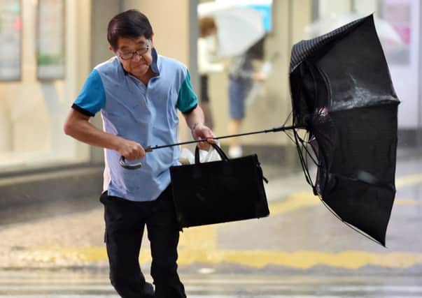 A man struggles against wind and rain in Tokyo as Japan braces itself for the effects of a second Typhoon. Picture: Getty