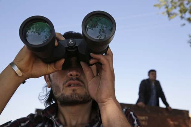 A Turkish Kurd on the Turkey-Syria border watches the fighting between Islamic State group and Kurdish forces. Picture: AFP