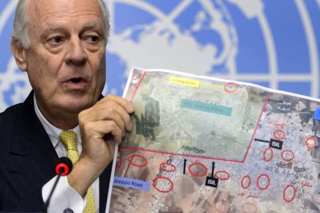 Staffan de Mistura holds up images showing the Islamic States advance on Kobani. Picture: Getty