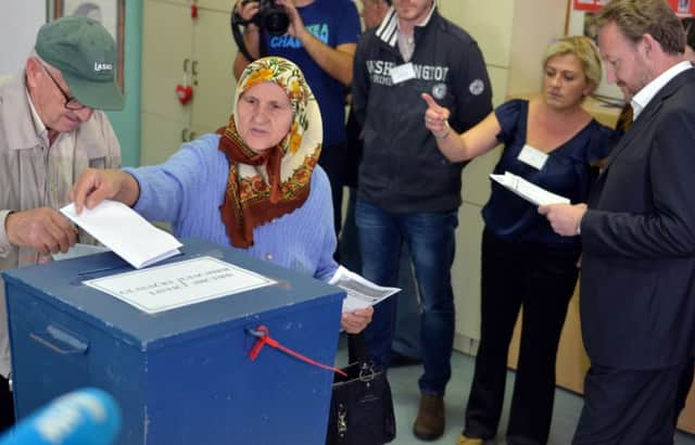 Bakir Izetbegovic, right, member of Bosnia's tripartite Presidency waits to vote at a polling station in Sarajevo. Picture: Getty