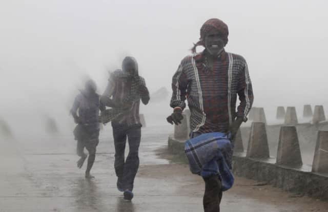 People run for shelter as the ferocious wind ripped into the Bay of Bengal Coast. Picture: AP