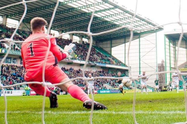 Dumbarton goalkeeper Danny Rogers dives to save a penalty by Hibs Dominique Malonga. Picture: SNS