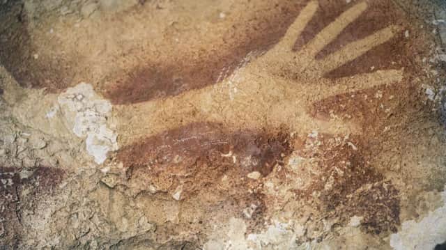 The silhouette of a hand on a cave wall in Maros karsts on Sulawesi is 40,000 years old. Pictue: Getty