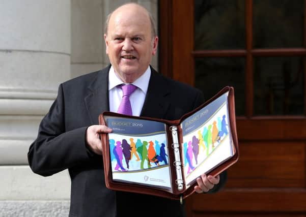 Irish Finance Minister Michael Noonan poses for pictures with the Irish 2015 budget outside the goverment buildings in Dublin. Picture: PA