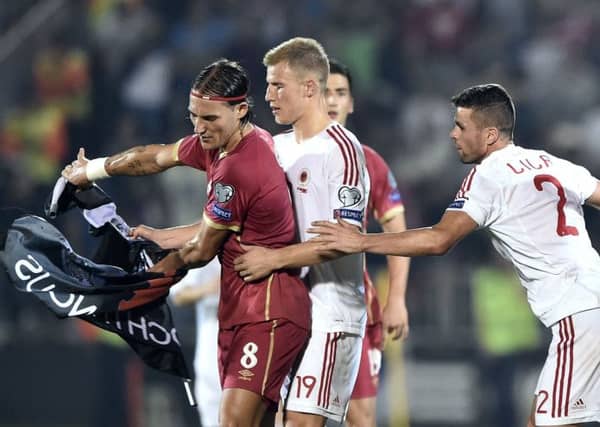 Nemanja Gudelj (L) scuffles with Albanian pair Bekim Balaj (C) and Andi Lila (R) over the flag. Picture: Getty