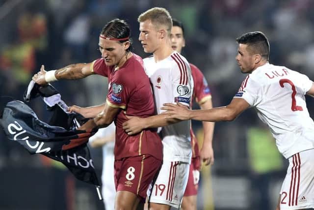 Nemanja Gudelj (L) scuffles with Albanian pair  Bekim Balaj (C) and Andi Lila (R) over the flag. Picture: Getty