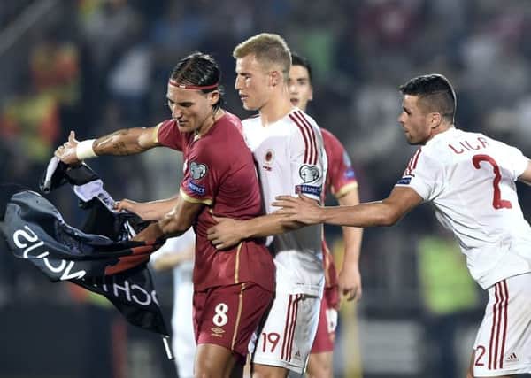 Nemanja Gudelj (L) scuffles with Albanian pair  Bekim Balaj (C) and Andi Lila (R) over the flag. Picture: Getty