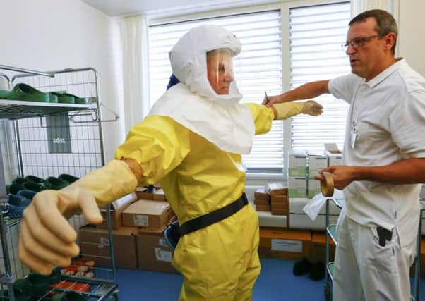 An infection control nurse demonstrates a protection suit. Picture: Reuters