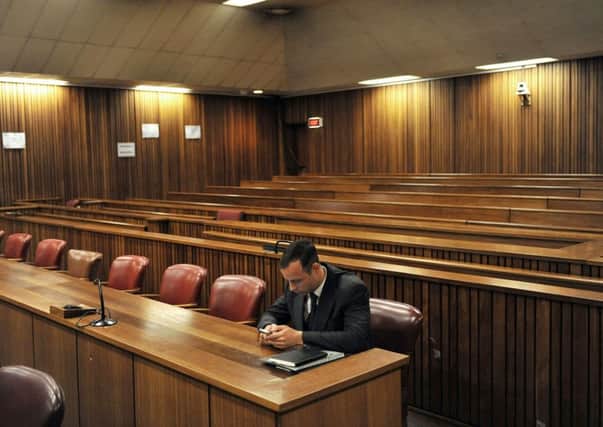 Pistorius sits alone in the high court in Pretoria apparently texting on his mobile phone as he awaits sentencing. Picture: Getty