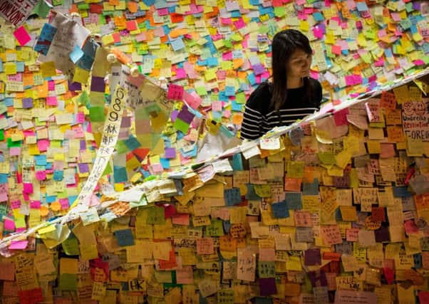 A woman looks at prodemocracy notes stuck to a stairwell outside Hong Kongs government complex. Picture: Getty