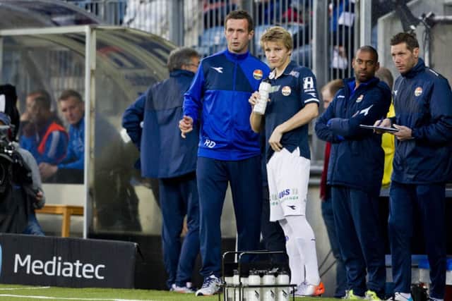 Martin Odegaard watches from the touchline alongside Stromsgodset manager Ronny Deila in April. Picture: PA