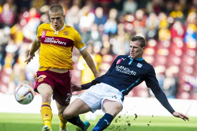 Dundee's Iain Davidson (right) slides in on Motherwell's Henrik Ojamaa. Picture: SNS