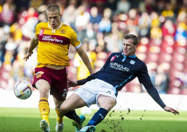 Dundee's Iain Davidson (right) slides in on Motherwell's Henrik Ojamaa. Picture: SNS