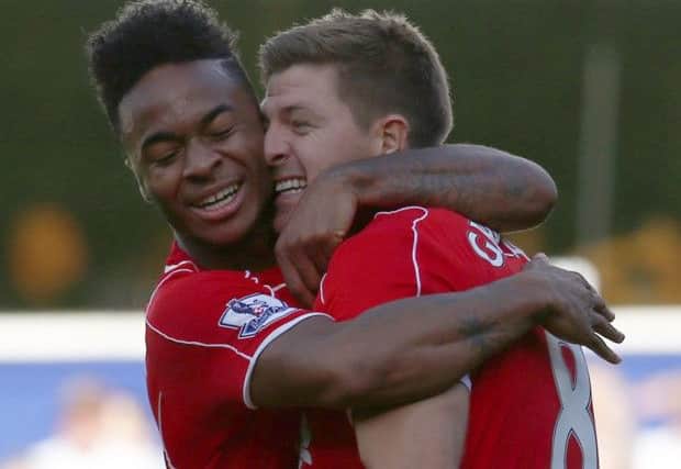 Raheem Sterling, left, celebrates with Steven Gerrard after his cross led to the winning goal. Picture: Reuters