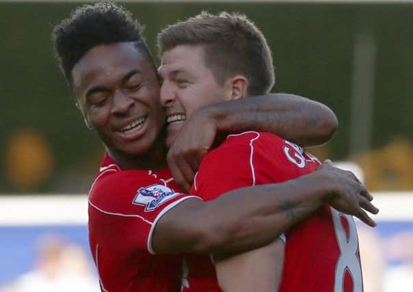 Raheem Sterling, left, celebrates with Steven Gerrard after his cross led to the winning goal. Picture: Reuters