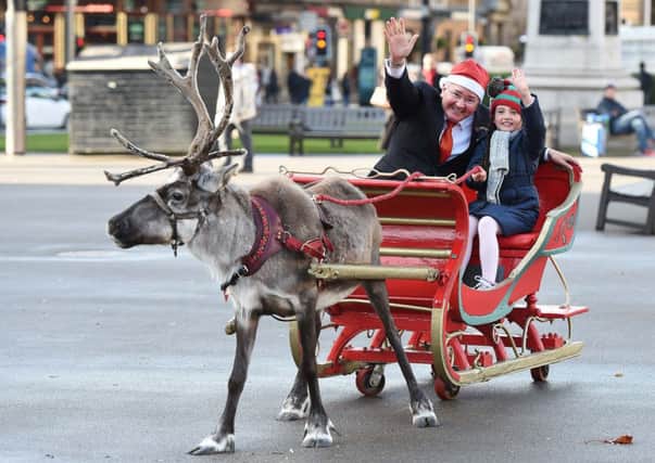 Councillor Gordon Matheson was in George Square today along with eight year old Erin McAllister meeting the reindeer and having a go on Santas sleigh. Picture: Contributed
