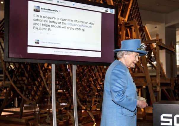 Queen Elizabeth II reads her first tweet after pushing a button to send it. Picture: Getty
