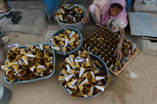 An Indian woman sells handmade cones for fireworks. Picture: Getty