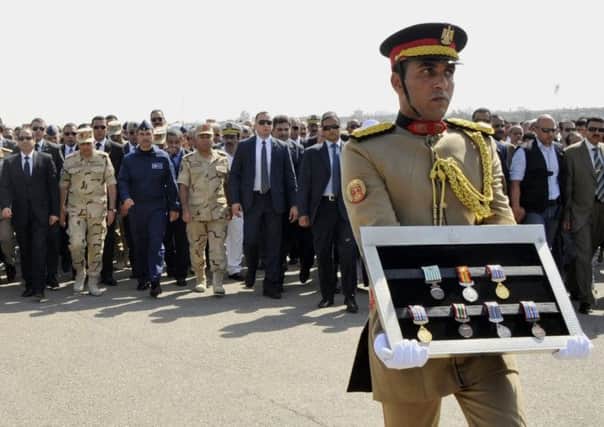 Egyptian President Abdel-Fattah el-Sissi, far left, and other officials follow a soldier carrying medals of troops killed in Friday's assault in the Sinai Peninsula. Picture: AP
