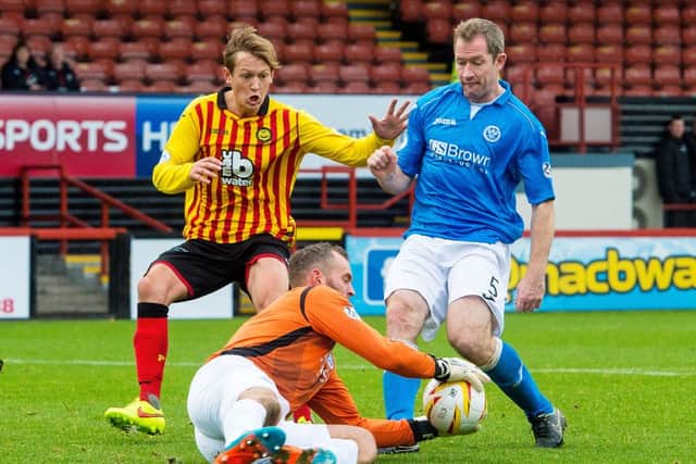 St Johnstone goalkeeper Alan Mannus takes the ball away from James Craigen (left) and Frazer Wright (right). Picture: SNS