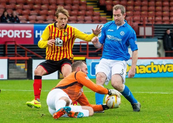 St Johnstone goalkeeper Alan Mannus takes the ball away from James Craigen (left) and Frazer Wright (right). Picture: SNS