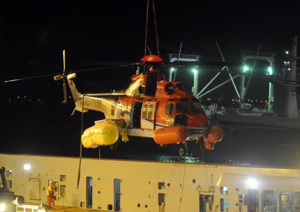 The CHC Super Puma Helicopter, that ditched into the north sea near Orkney this week carrying 19 oil workers, is craned back to shore. Picture: Hemedia