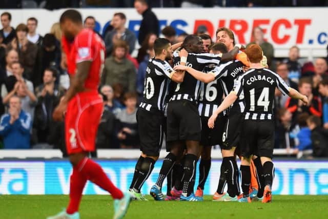 Glen Johnson walks away as the Newcastle players celebrate Ayoze Perezs goal. Picture: Getty