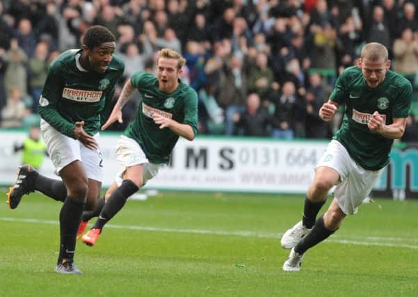 Dominique Malonga, far left, celebrates after firing Hibs in front against Hearts. Picture: Neil Hanna