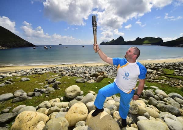 Colin Macleod holds the Glasgow 2014 Queen's Baton on the island of Hirta, the largest island in the St Kilda archipelago in the Outer Hebrides. Picture: Glasgow 2014