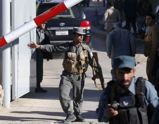 Officers guard the gate to police headquarters in Kabul yesterday in the wake of a suicide attack. Picture:Reuters