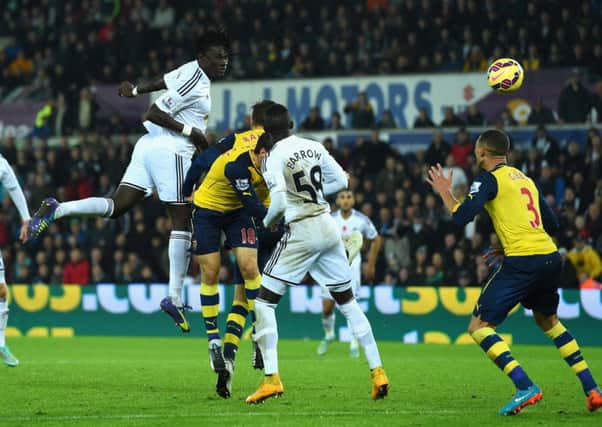 Swansea substitute Bafetimbi Gomis climbs above the Arsenal defence in the 78th minute to head home. Picture: Getty