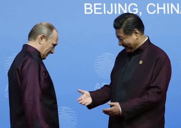 Xi Jinping had smiles for Mr Putin at least as he admired his fashion gesture. Picture: Reuters
