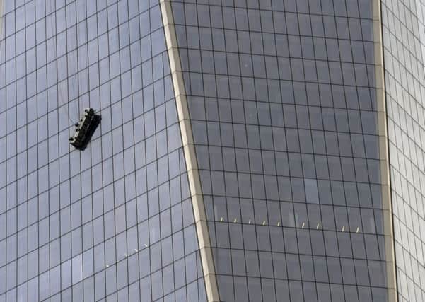 Stranded window washers hang from scaffolding on the side of One World Trade Center. Picture: Getty
