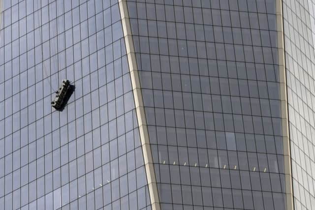 Stranded window washers hang from scaffolding on the side of One World Trade Center. Picture: Getty