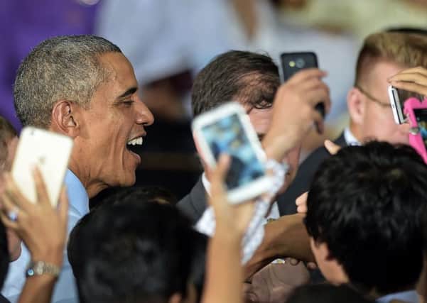 President Obama smiles as members of the audience take pictures of him. Picture: Getty
