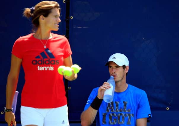 Andy Murray drinks water as he practices with his coach, Amelie Mauresmo. Picture: Getty