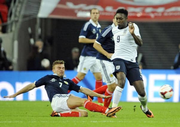 James Morrison tackles Danny Welbeck during last year's match at Wembley. Picture: Phil Wilkinson