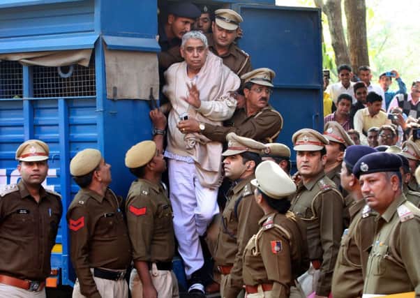 Sant Rampal is escorted from a police vehicle, surrounded by officers, following his arrest. Picture: AFP/Getty