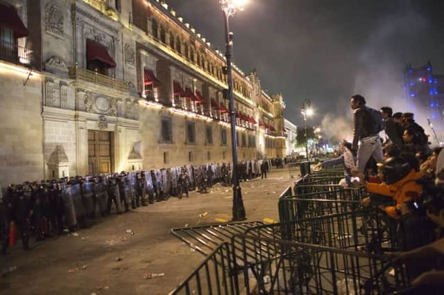 Protesters face police over barriers surrounding the National Palace in Mexico City. Picture: AP
