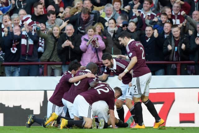 Jason Holt (hidden) is mobbed by his team-mates after putting Hearts 1-0 up. Picture: SNS
